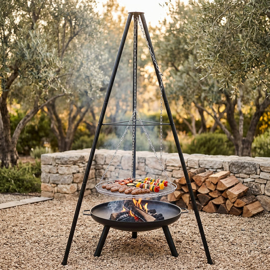 Barbecue trépied Helvor en cuisson au feu de bois dans un jardin
