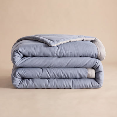Couette d'été légère matelassée bleue pliée, envers gris réversible