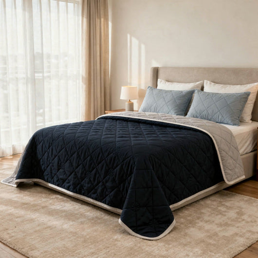 Couette rafraîchissante bleu marine réversible sur un lit en chambre