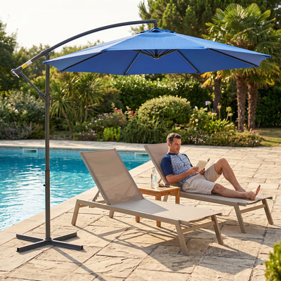 Parasol déporté octogonal bleu près d'une piscine et de transats