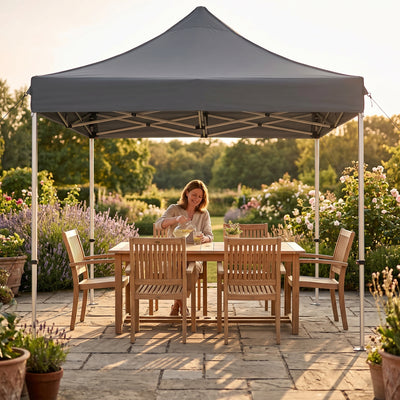 Tonnelle pliante grise installee sur une terrasse avec salon de jardin