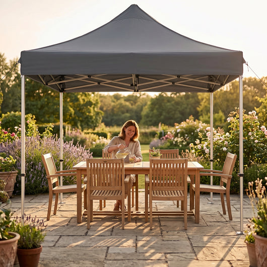 Tonnelle pliante grise installee sur une terrasse avec salon de jardin